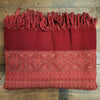 A rich red 100% acrylic multi-pattern shawl with fringed edges and geometric floral designs for summer evenings