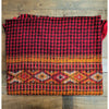 A 100% acrylic multi-pattern shawl with red and black plaid and orange tribal motifs for summer evenings use