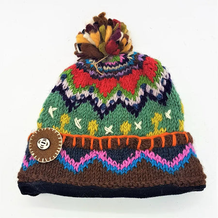 A wool bobble hat with a multicoloured felt bobble and geometric pattern made from zealand wool