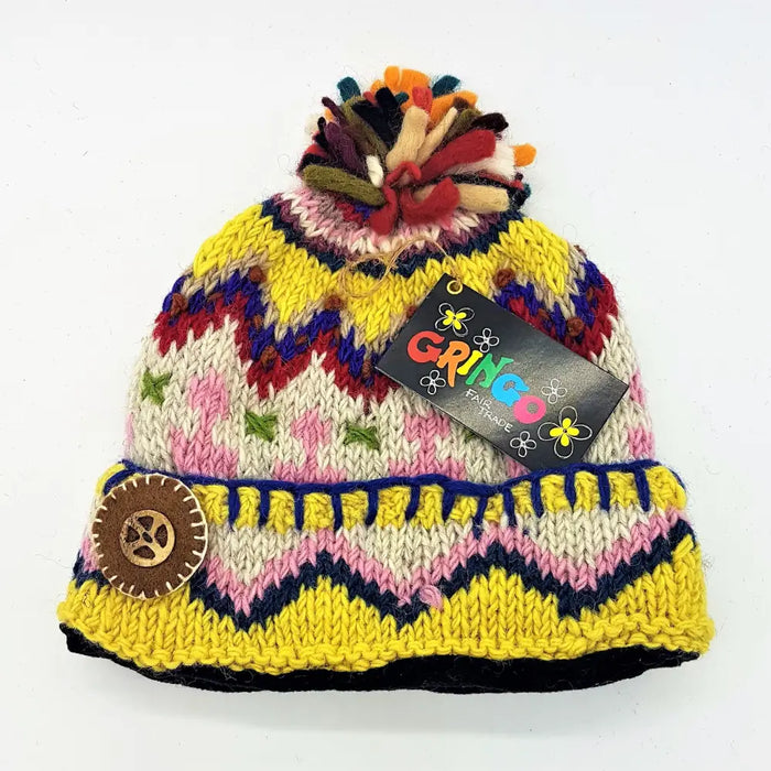 A colorful wool bobble hat with a multicoloured felt bobble and decorative button made from zealand wool