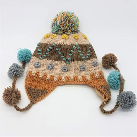 A cozy wool bobble hat in cream with multicolored pom-pom tassels and textured embroidery for kids and small adults