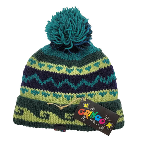A knitted bobble hat with lime green navy and teal zigzag stripes and a teal dark green pom pom made from zealand wool fair trade
