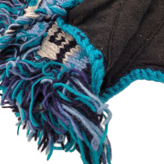 A fair trade 100% wool knitted mohican hat with a dark brown base and teal navy cream fringe made from Zealand wool