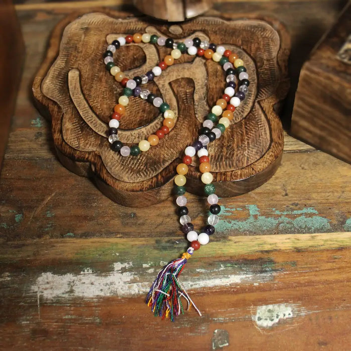 A colorful 108 bead mala necklace with multicolored gemstone beads and a vibrant tassel for planet astro use