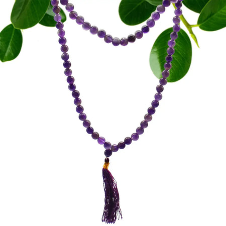 A purple amethyst bead mala necklace with 108 beads and a matching tassel pendant shown with velvet pouch