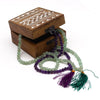 Wooden box with white geometric inlay holding green and purple jade bead mala necklace with velvet pouch