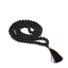 Black agate mala necklace with 108 black beads, gold-colored knot, black tassel, and velvet pouch background