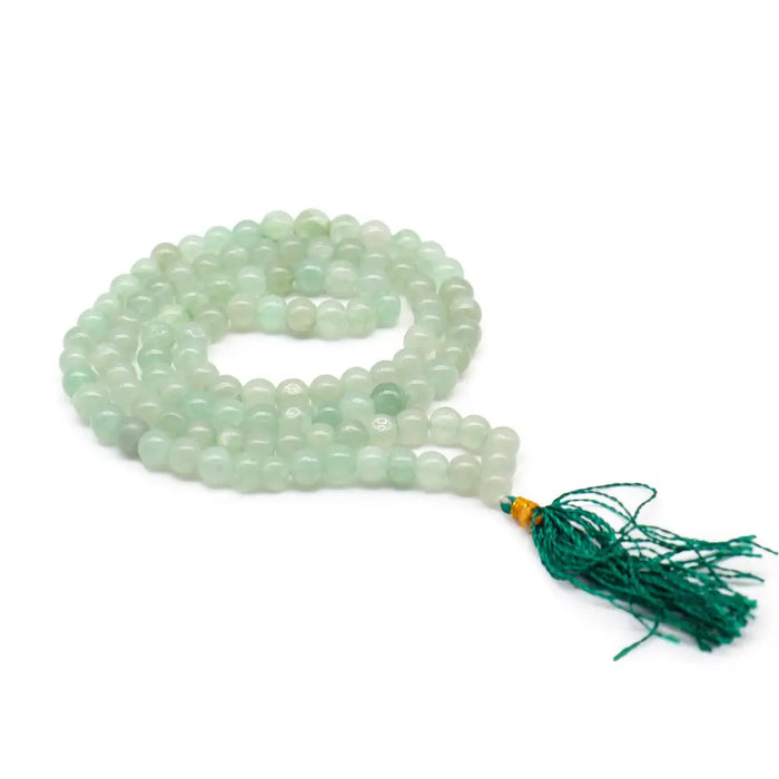 A green aventurine mala necklace with 108 translucent beads and a vibrant emerald tassel in a velvet pouch