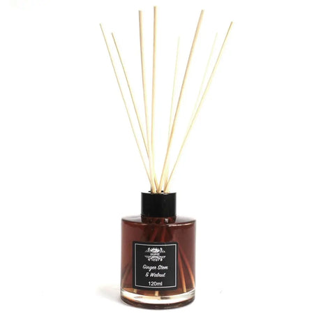 A sleek amber glass bottle reed diffuser with a black cap and light beige wooden reeds for ginger stem scent