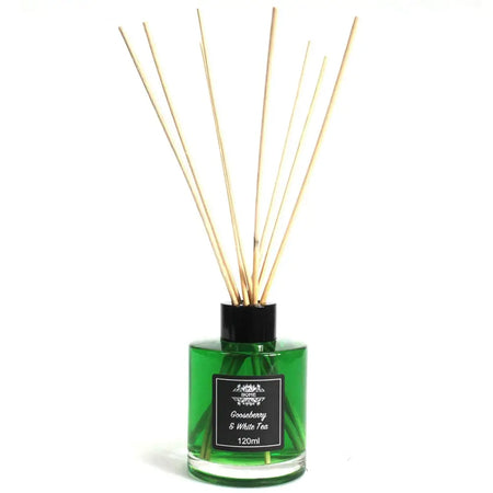 Green glass tea reed diffuser with black cap and label and light wood reeds for a white tea reed oil lasts 120ml