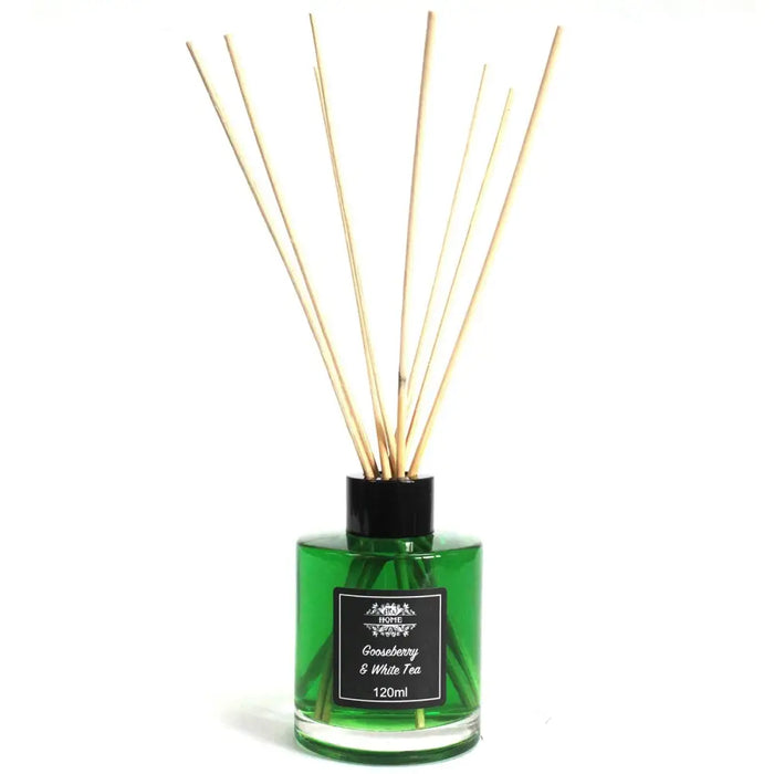 Green glass tea reed diffuser with black cap and label and light wood reeds for a white tea reed oil lasts 120ml