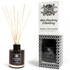 White strawberry and blackberry reed diffuser in a clear glass bottle with black cap and natural wooden reeds