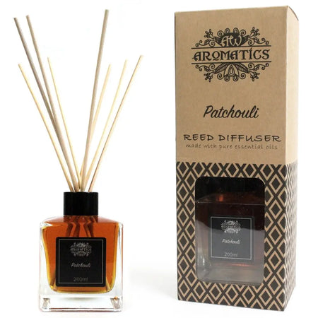 A clear glass reed diffuser bottle with amber patchouli essential oil in an eco-mineral oil base and black cap by aromatics