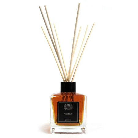 A square glass 200ml patchouli essential oil reed diffuser with amber liquid and light beige wooden reeds in eco-mineral oil base
