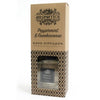 A clear glass reed diffuser bottle with black label and rattan sticks in a brown box with aromatics brand and frankincense essential oil