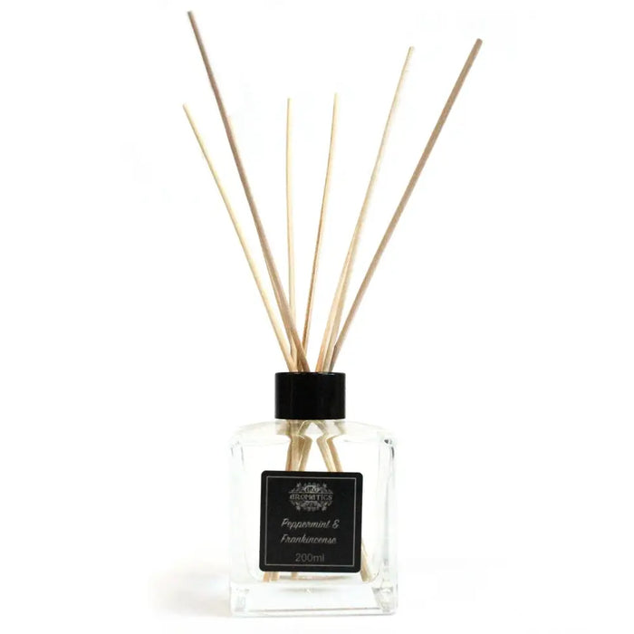 Clear glass reed diffuser with black cap and light wooden rattan sticks with peppermint frankincense essential oil
