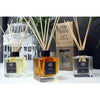 Three square glass reed diffusers with wooden reeds filled with lemon nutmeg yellow amber patchouli and clear lavender fennel oils