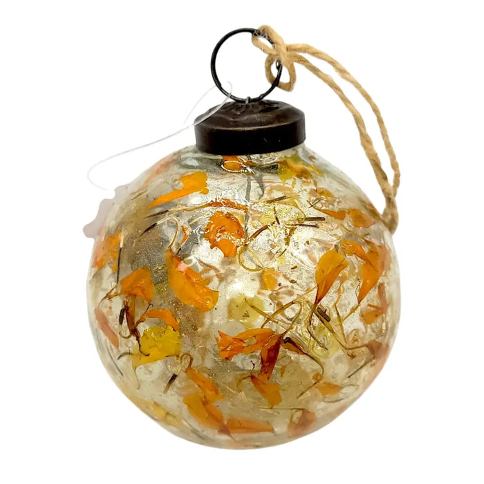 Clear glass christmas ornament with embedded amber botanical dried flower petals sealed with metal cap and twine