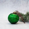 A 3 inch emerald glass ribbed ball christmas decoration with a brass cap and sheer brown ribbon