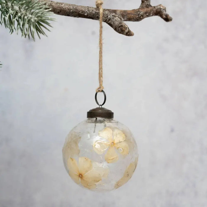 3 inch clear glass floral botanical bauble with dried cream flowers hanging by rustic twine loop