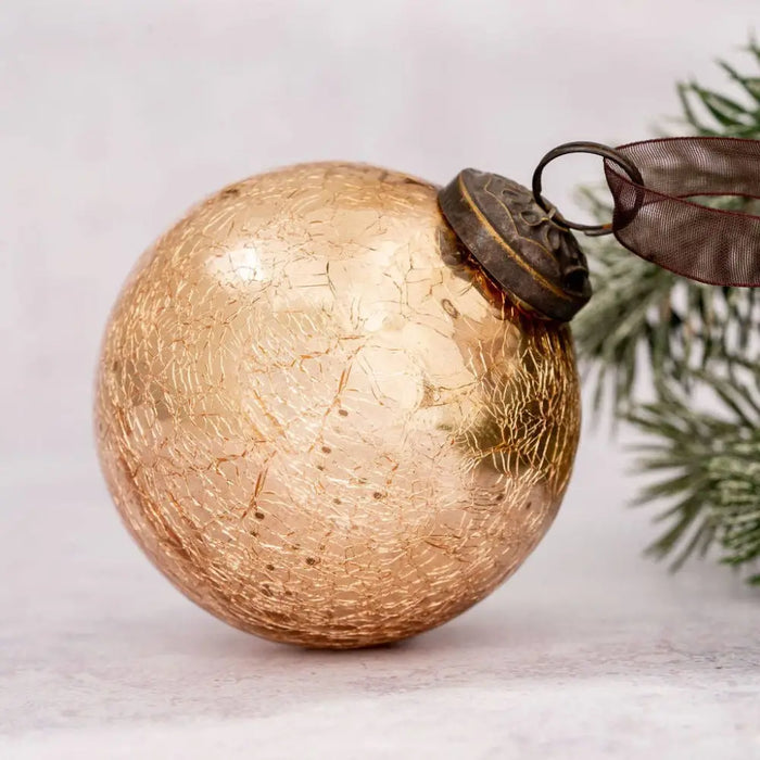 A 3 inch large champagne crackle glass bauble with vintage gold mercury glass, dark metal cap, and attached ribbon