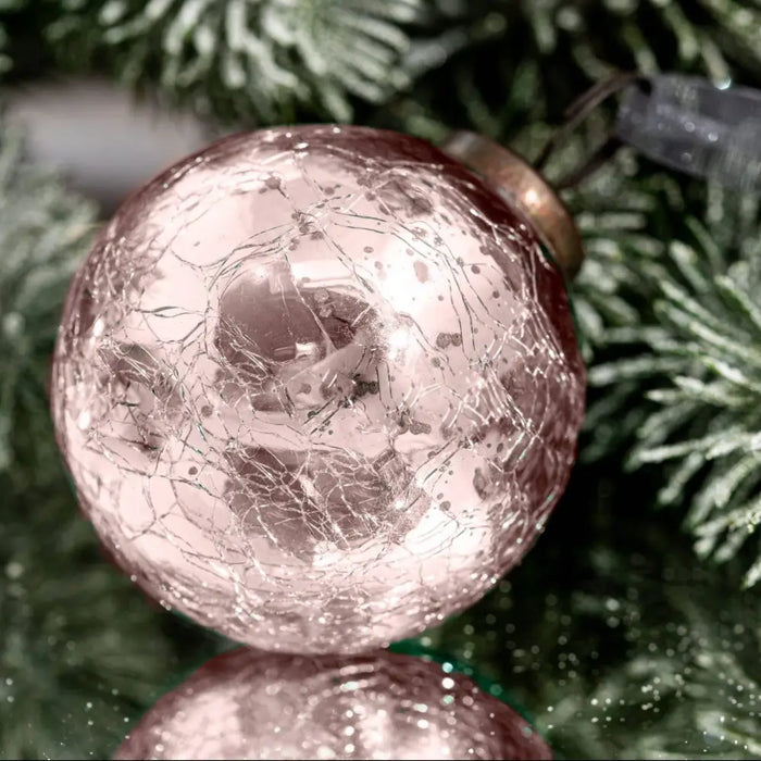 A 3 inch large rose quartz crackle glass christmas bauble with a metallic gold cap on a plain background