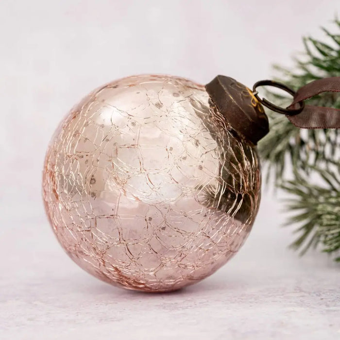 A 3 inch large rose quartz crackle glass christmas bauble with a dark metal cap and loop for hanging