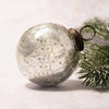 A 3 inch large silver crackle glass christmas tree bauble ornament with a metallic gold rim and loop