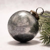 A 3 inch large slate crackle glass ball christmas ornament with a silver crackled finish and brass cap and loop