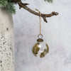 Clear glass 3 inch leaf botanical bauble with gold leaf ferns and brass cap hanging from twine