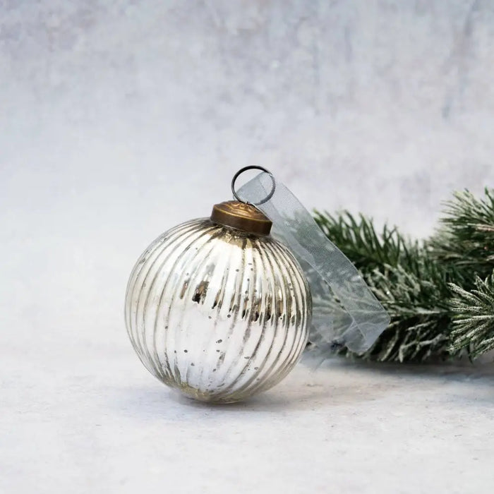 A 3 inch silver glass ribbed ball decoration with vertical ridges and a brass colored cap vintage style mercury glass ornament