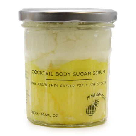 A yellow pina colada sugar body scrub with shea butter in a clear glass jar with silver lid 300g container