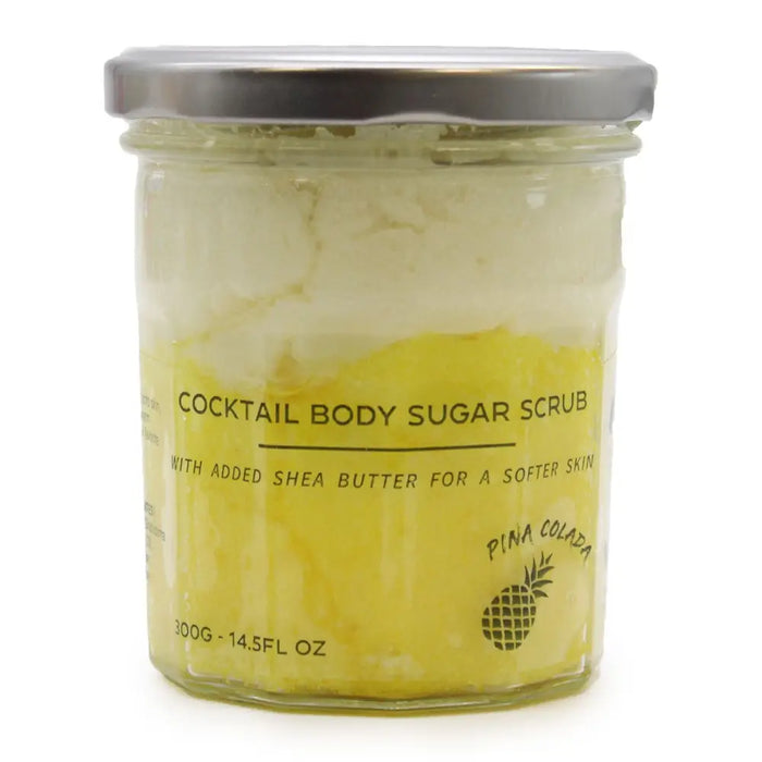 A yellow pina colada sugar body scrub with shea butter in a clear glass jar with silver lid 300g container
