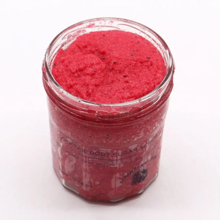 A vibrant red strawberry rum sugar body scrub in a clear jar with black text for dry skin care use