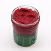 A vibrant red and green layered sugar body scrub in a clear jar for dry skin exfoliation called watermelon daquiri