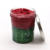 A clear glass jar with silver lid holds a vibrant red watermelon daquiri body sugar scrub for dry skin care