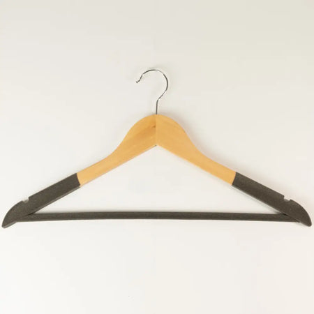 Light wood-tone wooden hanger with shaped shoulders black ends and silver hook for hanging complete outfits