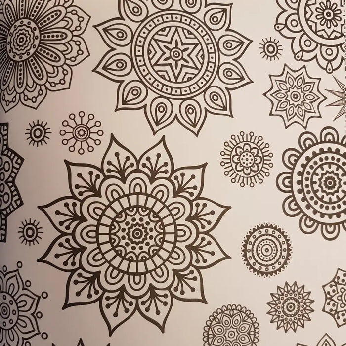 Adult colouring book with beige pages featuring intricate black mandala patterns for zen colouring