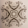 A black and white intricate mandala drawing with symmetrical paisley-like patterns in an adult colouring book