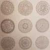 An adult colouring book page with nine black and white mandala designs on light paper for zen colouring