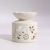 Cream-colored ceramic oil diffuser with floral and leaf cutouts in agnes and cat fragrance gift set windermere