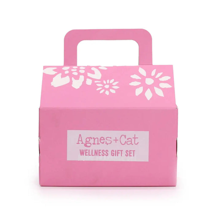 Pink cardboard wellness gift set box with white floral cutouts and handle labeled agnes cat cat wellness gift