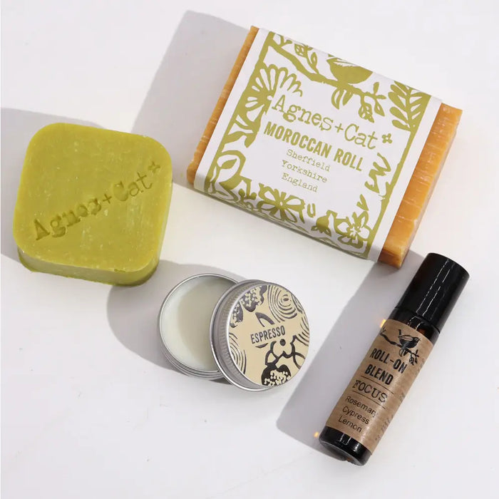 A rectangular yellow-orange moroccan soap bar wrapped in white and olive-green paper labeled agnes and cat wellness gift set
