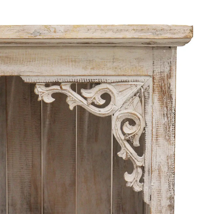 A distressed white wooden corbel with intricate scrollwork on an albasia bathroom cabinet whitewash bathroom cabinet
