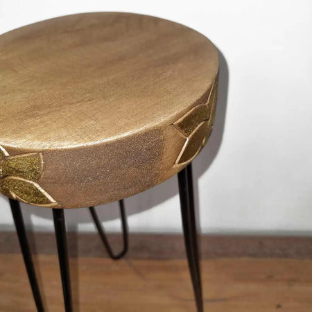 Golden round side table with leaf-patterned albasia wood top and black hairpin legs as a plant stand
