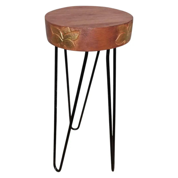 Round wooden albasia wood plant stand with carved gold leaf patterns and black hairpin legs in terracotta and gold colors