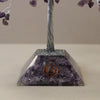 A purple amethyst gemstone tree with twisted silver wire trunk and heart charms on a resin base with crushed stones