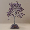 A purple amethyst gemstone tree with silver wire frame and organite pyramid base filled with embedded crystals