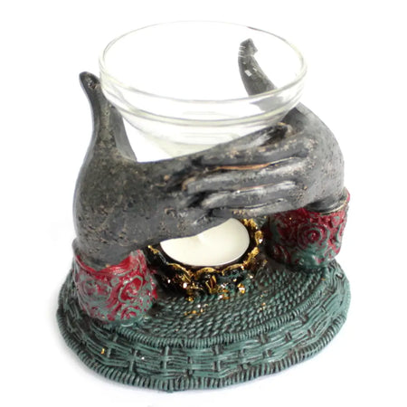 Dark gray hand-shaped oil burner with red and green floral accents holding glass tea light on gold-trimmed base