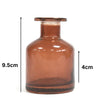 A translucent amber glass apothecary style reed diffuser bottle with a short wide body and a bamboo reed diffuser stopper